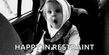 a baby is sitting in a car seat and making a face .