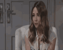 a woman is sitting in a chair with her mouth open and looking at the camera .