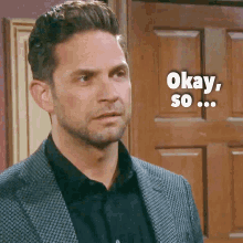 a man in a suit says okay so while standing in front of a door