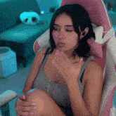 a woman is sitting in a pink and white chair with the word ar on the back