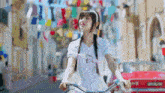 a girl with pigtails is riding a bike down a street .