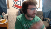 a man wearing headphones and a green shirt with the letter s on the front