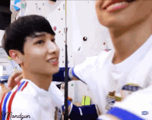 two young men are standing next to each other and smiling .