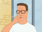 a man with glasses is smoking a cigarette in front of a brick wall
