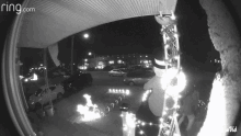 a black and white photo of a ring.com doorbell with christmas decorations