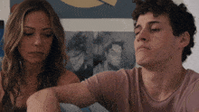 a man and a woman are sitting next to each other in front of pictures