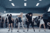 a group of women are dancing in front of a tank