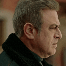 a close up of a man 's face with a black jacket on