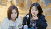 two girls are eating marshmallows with the words things better on the top