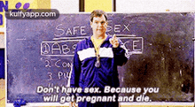 a man is standing in front of a blackboard with safe sex written on it