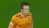 a soccer player wearing a yellow shirt that says karoo on it