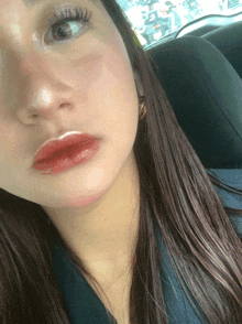 a close up of a woman 's face with red lips and long eyelashes