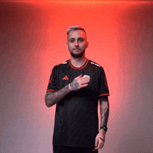 a man wearing a black shirt that says adidas