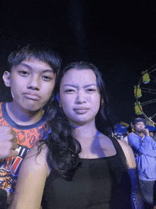 a boy and a girl are posing for a picture and the girl is wearing a shirt that says u.