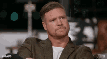 a man with a beard is sitting on a couch with the hashtag mafs