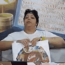 a woman in a white shirt is sitting in front of a sign that says youtube.com