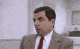 a man in a suit and tie is making a surprised face .