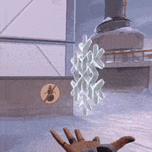 a person 's hand is reaching for a snowflake in front of a no snowman sign