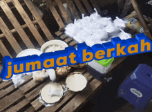 a blue sign that says jumat berkah sits on a wooden bench
