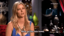 a woman in a blue dress is sitting in a chair and says bitch go the fuck home