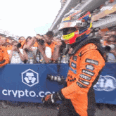 a man in a helmet stands in front of a sign that says crypto