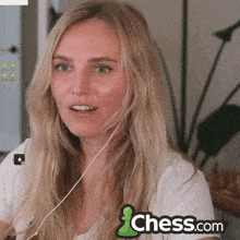a woman is wearing headphones and a chess.com logo is behind her