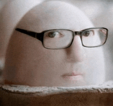 a close up of a person 's face with glasses .