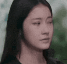 a close up of a woman 's face with her eyes closed and a serious look on her face .