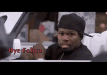 a man in a black hat is sitting in a car and says bye felica