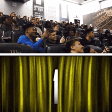 a group of people sitting in a theater with a sign that says wake up and defense