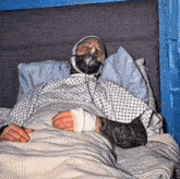 a man in a hospital gown with an oxygen mask on his face