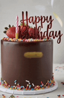 a chocolate birthday cake with strawberries , candles and sprinkles .