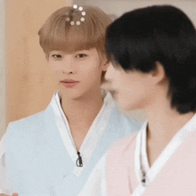 two young men are standing next to each other in traditional clothes .