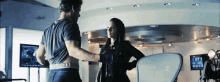 a man and a woman are standing next to each other in a room with a chair .