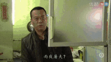 a man standing in front of a refrigerator with chinese writing on the door