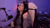 a woman is sitting in a chair wearing headphones and looking up at the sky .