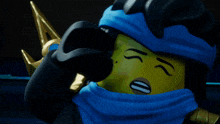 a close up of a lego figure with a blue scarf around her neck