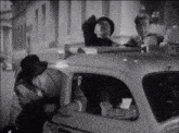three men are sitting in a taxi with a yellow sign on the top