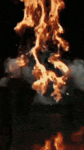 a close up of a fire with smoke coming out of it in a dark room
