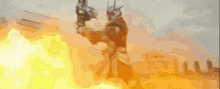 a man in a knight 's armor is holding a gun in front of a fire