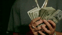 a person is holding a stack of money in their hands