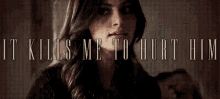 a woman is standing in front of a wall with the words `` it kills me to hurt him '' written on it .