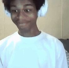 a man wearing headphones and a white shirt looks at the camera .