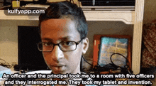 a boy wearing glasses is sitting in a room with five officers and they interrogated me .
