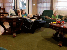 a group of children are laying on a couch with a toy car on the table