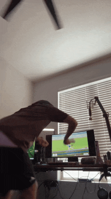 a man is playing a video game in front of a computer screen