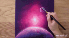 a person is painting a galaxy with a brush on a canvas made in animatica