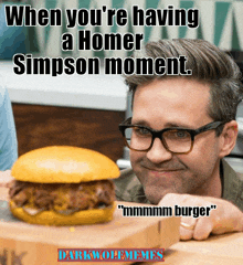 a man with glasses looks at a hamburger that says when you 're having a homer simpson moment "