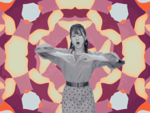 a woman in a polka dot skirt stands in front of a colorful kaleidoscope