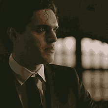 a close up of a man in a suit and tie looking at the camera .